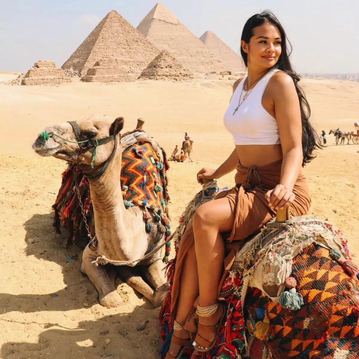 American asian girl on the camel next to the pyramids in Giza with iEgypt tours